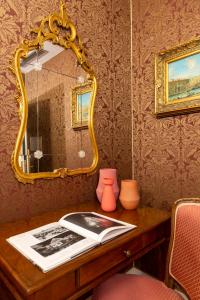 a table with a mirror and a book on it at Hotel Antico Doge - a Member of Elizabeth Hotel Group in Venice