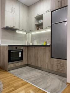 a kitchen with wooden cabinets and a large refrigerator at Apartman SM Kragujevac II in Kragujevac