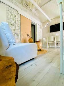 a living room with a white couch and a table at Casa De Palmas - Tiny house in Alkmaar