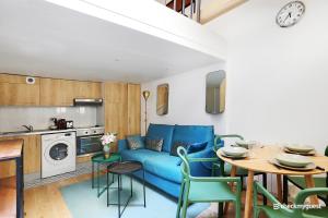 a living room with a blue couch and a table at CMG Gambey / Paris 11ème in Paris