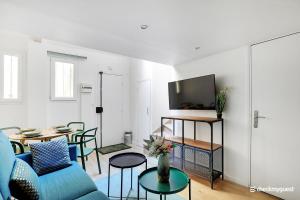 a living room with a blue couch and a table at CMG Gambey / Paris 11ème in Paris