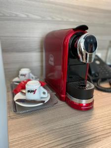 a red coffee maker sitting on a counter with a cup at Abasto Hotel München Feldmoching in Munich