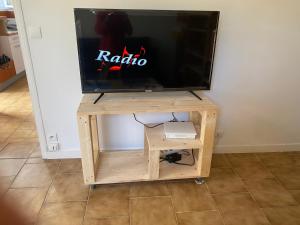 a tv on a wooden stand with a tv on it at Chez Marilou in Saint-Dizier