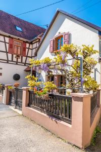 a house with flowers on a fence at Les Tilleuls in Wissembourg