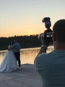 un hombre tomando una foto de una novia y un novio en Guesthouse Rebel en Deliblato