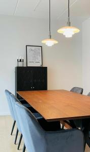una sala da pranzo con tavolo in legno e sedie blu di ApartmentInCopenhagen Apartment 1463 a Copenaghen
