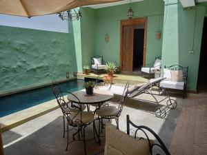 a patio with a table and chairs next to a pool at Casa Colonial Koenig in São Filipe