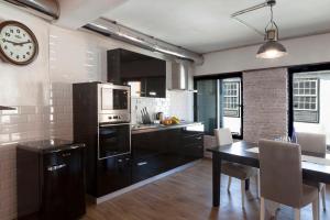 kuchnia ze stołem i zegarem na ścianie w obiekcie El Hierro Bed & Loft w mieście Valverde