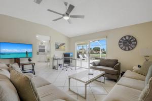 マルコ・アイランドにあるPet-friendly home with southern exposure and poolのリビングルーム(ソファ、壁掛け時計付)