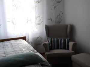 1 dormitorio con silla, cama y ventana en Am Klinikum, en Solingen