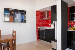 a kitchen with black appliances and a red brick wall at ELHIERRO BED&URBAN I in Valverde