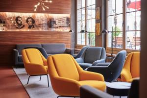 a waiting room with blue chairs and yellow chairs at 5th Floor Basic Rooms - shared bathrooms in Interlaken +30 photos