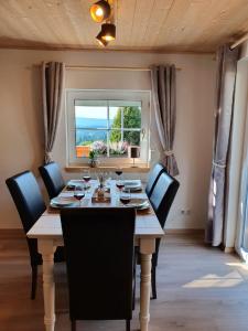 a dining room with a table and chairs and a window at Fichtelfeeling in Fichtelberg