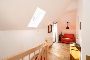 Cette chambre est dotée d'un escalier et d'une chaise rouge. dans l'établissement Les Tilleuls, à Wissembourg