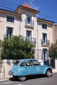 a blue car parked in front of a building at Le Petit Molière in Servian