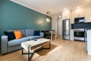 a living room with a couch and a table at Appart Hôtel Le Saint-Anselme - Par Revenus Locatifs Qc in Quebec City