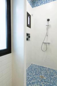 uma casa de banho com um chuveiro e piso em azulejo azul em ELHIERRO BED&URBAN I em Valverde
