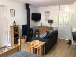 a living room with a couch and a wood stove at Meerkat Manor in Coddington