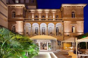 an exterior view of a building at night at Villa Adriatica Ambienthotels in Rimini
