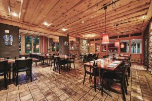 a restaurant with wooden ceilings and tables and chairs at Hotel Interlaken in Interlaken