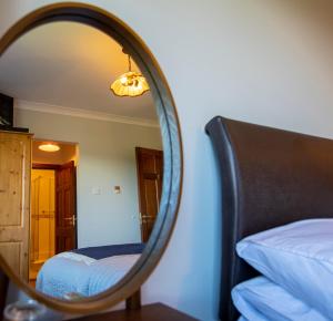 a mirror in a room with a bed and a bed sqor at Bunratty Meadows Bed & Breakfast in Bunratty