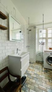 uma casa de banho branca com um lavatório e uma máquina de lavar roupa em ApartmentInCopenhagen Apartment 134 em Copenhague
