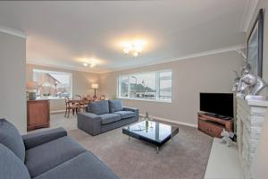 uma sala de estar com um sofá azul e uma televisão em Island View em Oban