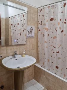 een badkamer met een wastafel en een douchegordijn bij Velamar Praia 411 - 300m da praia in Albufeira