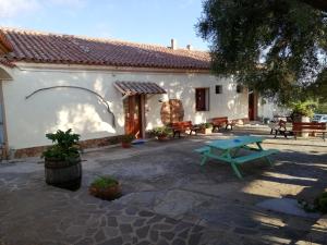 a house with a picnic table in front of it at B&B La Taerra in Porto San Paolo