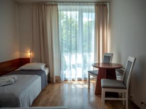 a bedroom with a bed and a table and a window at Kolejarz Natura Tour in Zakopane +86 photos
