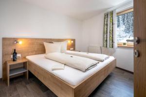 a bedroom with a large bed and a window at Haus Sabrina Rotpleiskopf in See