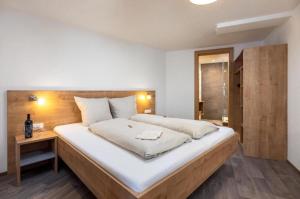 a bedroom with a large bed with a wooden headboard at Haus Sabrina Masnerjoch in See