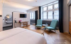 a bedroom with a bed and two chairs and a desk at Marktgasse Hotel in Zürich