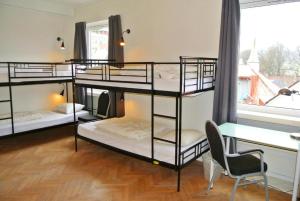 a bedroom with two bunk beds and a desk at City Hostel Bergen in Bergen