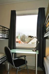 a desk with a chair in front of a window at City Hostel Bergen in Bergen
