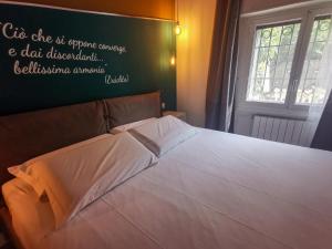 una camera da letto con un letto bianco con un cartello sul muro di L'Archè Comfort&Relax, Sweet Home via Eraclito a Milano