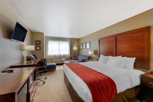 ヒューロンにあるComfort Inn River's Edgeの大きなベッドとデスクが備わるホテルルームです。