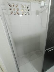W łazience znajduje się prysznic ze szklanymi drzwiami. w obiekcie Suíte agradável no centro da cidade. w mieście Boa Vista