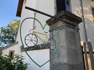 a bicycle is attached to the side of a building at Métris de la place in Corre