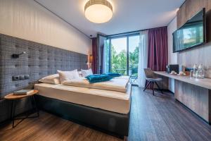 a bedroom with a large bed and a large window at Rufi's Hotel Innsbruck in Innsbruck