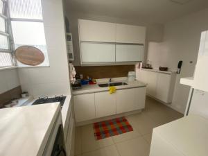 una cocina con armarios blancos y fregadero en FRONTAL MAR Copa en Río de Janeiro