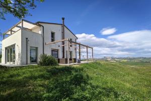 a white house on top of a grassy hill at Casa Luce in Torre di Palme