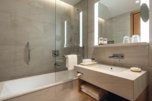 a bathroom with a sink and a shower at Mövenpick Hotel Basel in Basel
