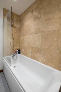 y baño con bañera y ducha. en Beautifully styled, central apartment sleeping 10, en Brighton & Hove