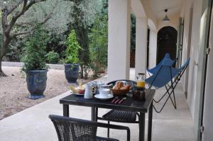 een tafel op een veranda met eten erop bij Chambres d'hôtes sous l'olivier in Montpellier