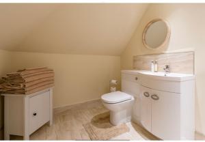 a bathroom with a white toilet and a sink at The Cartlodge in Wickham Bishops