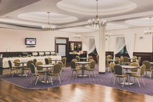 a dining room with tables and chairs and a bar at Hotel Czardasz Spa & Wellness in Płock
