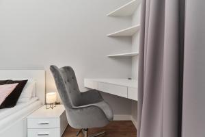 a bedroom with a desk and a chair next to a bed at Futuria Apartment Maślicka with FREE GARAGE Wroclaw by Renters in Wrocław