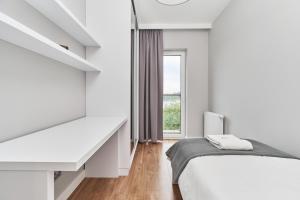 biała sypialnia z łóżkiem i oknem w obiekcie Futuria Apartment Maślicka with FREE GARAGE Wroclaw by Renters we Wrocławiu