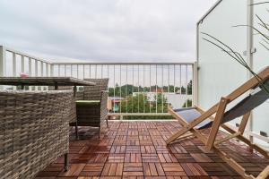 a balcony with a chair and a table at Futuria Apartment Maślicka with FREE GARAGE Wroclaw by Renters in Wrocław